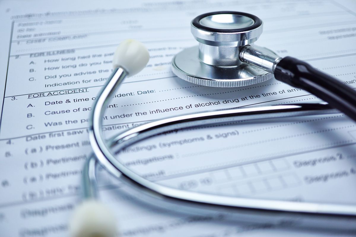 A stethoscope resting on a printed insurance claim form