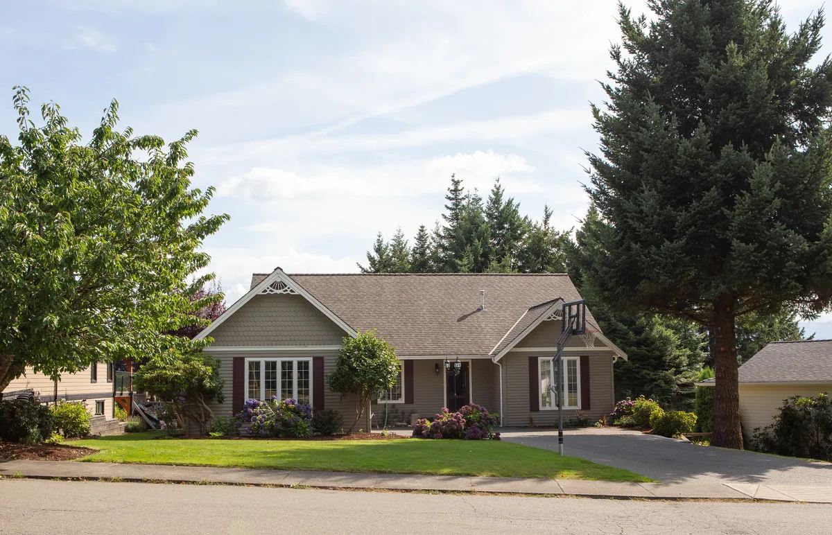 Single story home with a green lawn on a quiet residential street