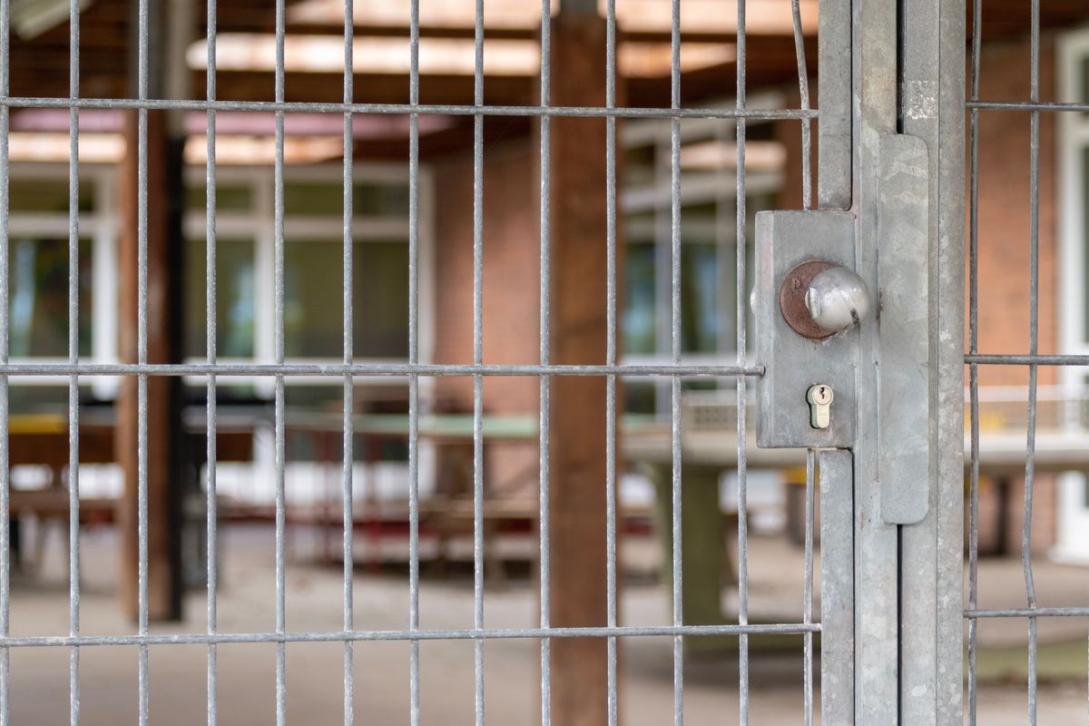 A metal gate with a lock closing off a building entrance.