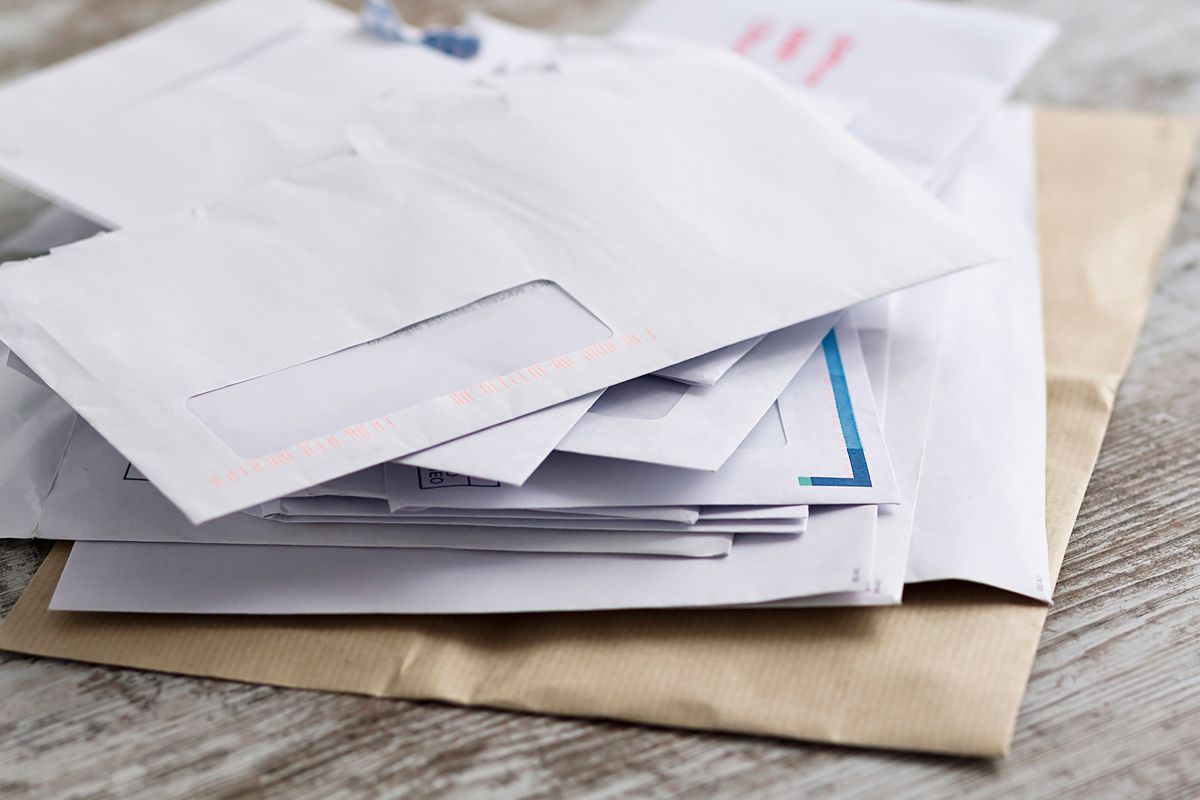 A pile of white envelopes on a wooden table