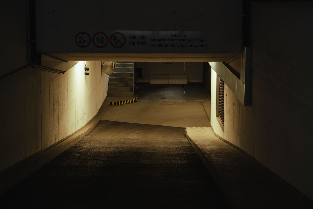 A dimly lit empty parking structure at night